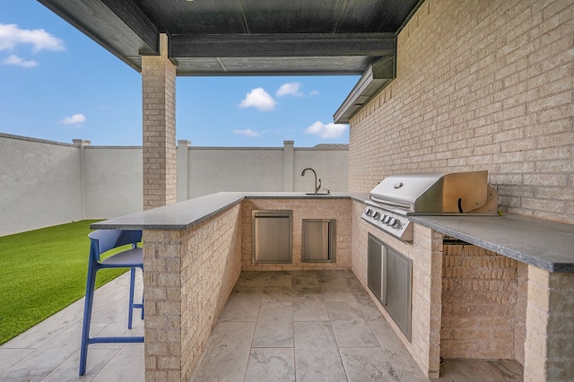 view of patio / terrace featuring fence, outdoor wet bar, and area for grilling