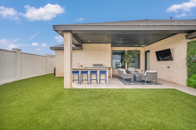 rear view of house with a ceiling fan, a lawn, a fenced backyard, an outdoor hangout area, and a patio area