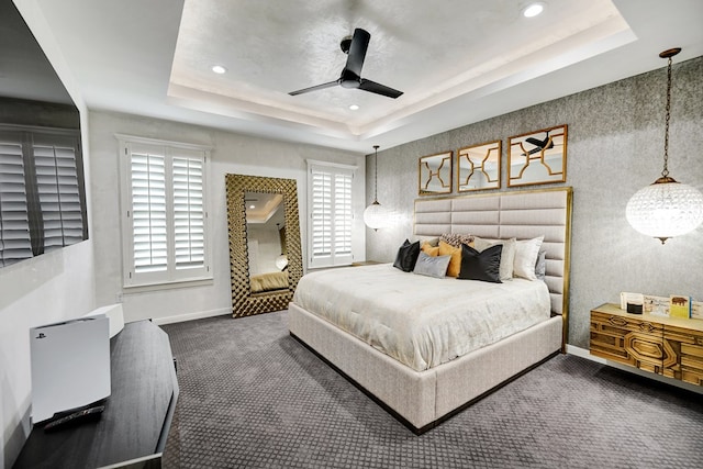 carpeted bedroom with a ceiling fan, recessed lighting, a raised ceiling, and baseboards