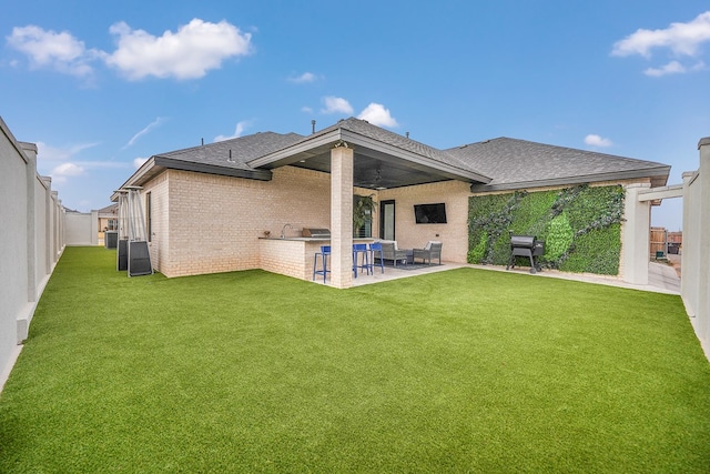 back of house featuring a fenced backyard, a patio, and a lawn