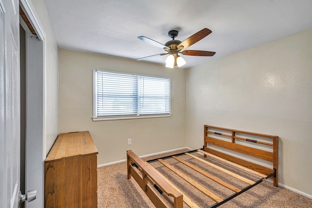 carpeted bedroom featuring baseboards and a ceiling fan