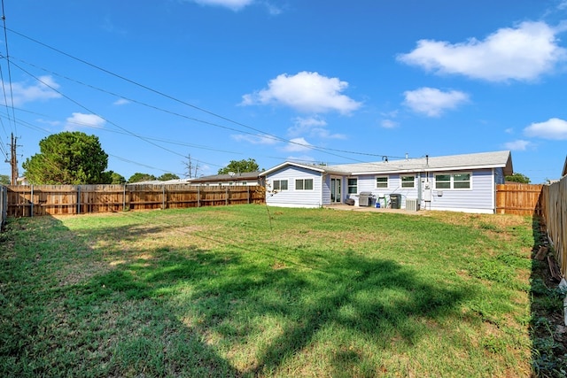 back of property with a lawn and a fenced backyard