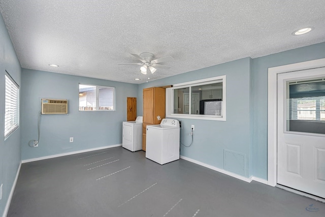 laundry area with washer and dryer, baseboards, a wall mounted air conditioner, ceiling fan, and cabinet space