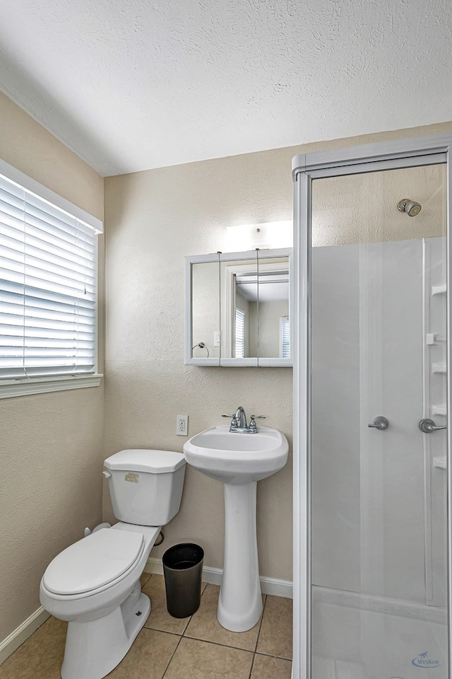 full bath featuring tile patterned flooring, toilet, and a shower stall