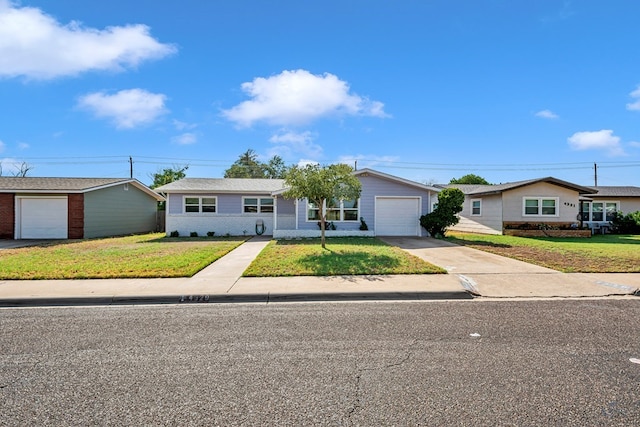 ranch-style house featuring brick siding, a garage, driveway, and a front lawn