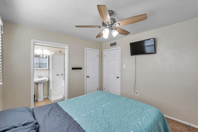 bedroom featuring ceiling fan, visible vents, a sink, baseboards, and ensuite bathroom