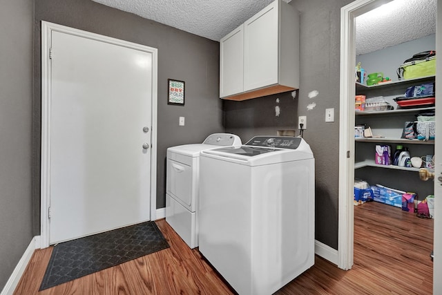 4107 Crestgate Ave, Midland, TX 79707 - washroom featuring a textured ceiling, cabinet space, washer and clothes dryer, wood finished floors, and baseboards