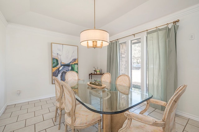 tiled dining room with crown molding, baseboards, and a tray ceiling