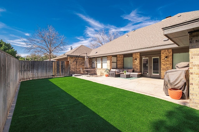 view of yard with a patio area, a fenced backyard, an outdoor hangout area, and french doors