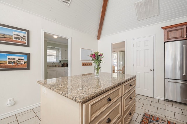 kitchen featuring light tile patterned floors, lofted ceiling with beams, light stone counters, visible vents, and freestanding refrigerator