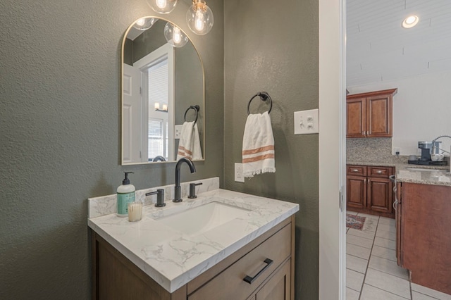 bathroom featuring a textured wall, tile patterned flooring, and vanity