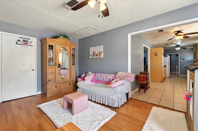 3216 W Dengar Ave, Midland, TX 79705 - bedroom with attic access, baseboards, light wood-style flooring, a ceiling fan, and freestanding refrigerator