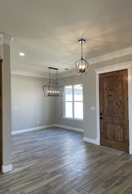 unfurnished dining area featuring baseboards, dark wood-style flooring, and crown molding