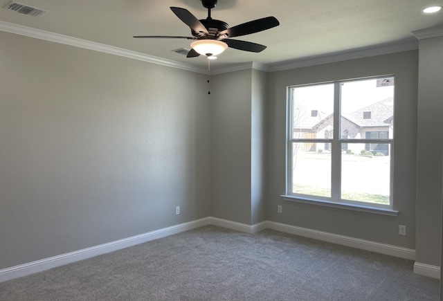 spare room with a wealth of natural light, visible vents, crown molding, and baseboards