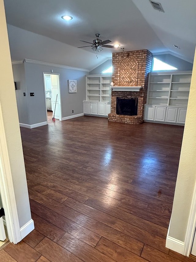 unfurnished living room featuring lofted ceiling, built in features, a fireplace, and dark hardwood / wood-style flooring