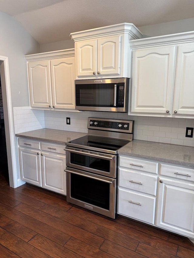 kitchen featuring appliances with stainless steel finishes, decorative backsplash, and white cabinets