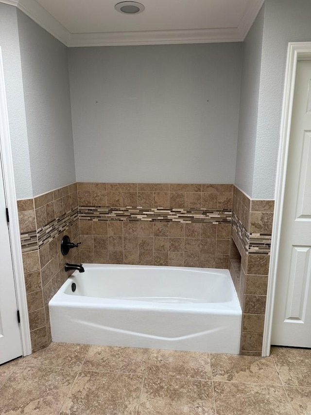 bathroom with a bath, crown molding, and tile walls