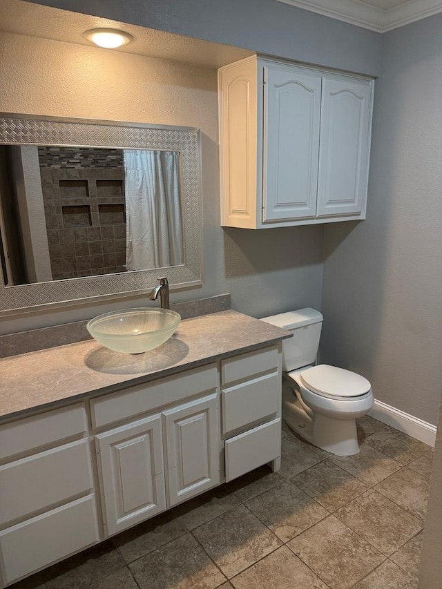 bathroom featuring toilet, vanity, and crown molding