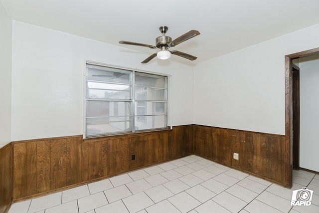 spare room with wood walls and ceiling fan