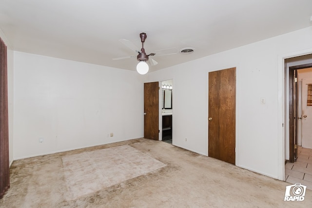 spare room with ceiling fan and light colored carpet