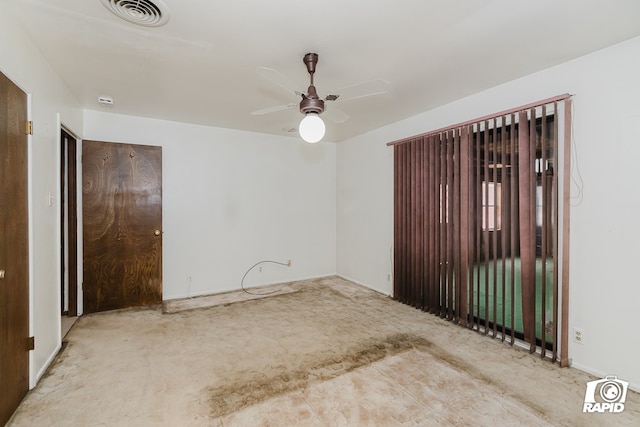 carpeted spare room featuring ceiling fan