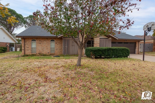 ranch-style house featuring a front yard and a garage