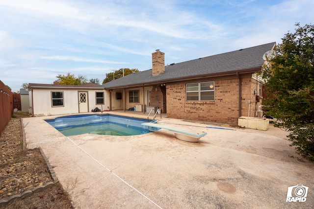 view of swimming pool featuring a diving board and a patio area