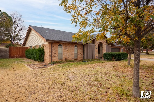 ranch-style house featuring a garage and a front yard