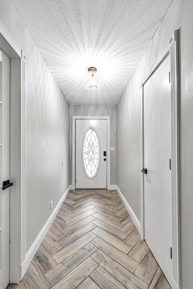 foyer entrance featuring a textured ceiling and light parquet flooring