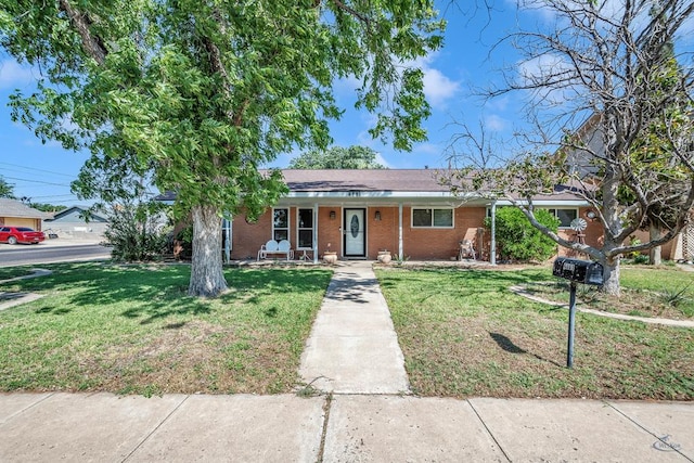 ranch-style house with covered porch, a front lawn, and brick siding