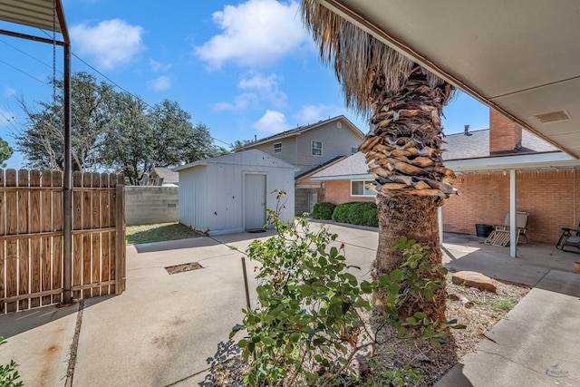 exterior space featuring an outbuilding, brick siding, a patio, a storage shed, and fence