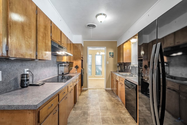 kitchen featuring visible vents, brown cabinets, under cabinet range hood, black appliances, and a sink