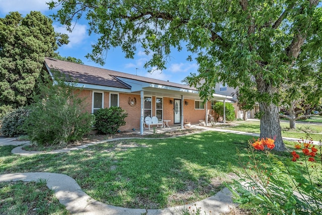 ranch-style home featuring brick siding and a front lawn