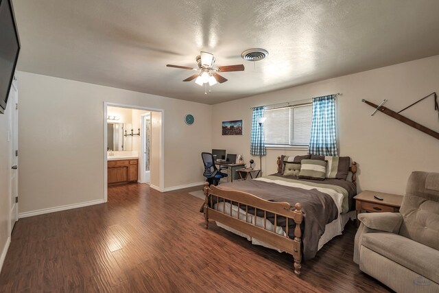 bedroom featuring baseboards, visible vents, a ceiling fan, dark wood-style floors, and ensuite bath