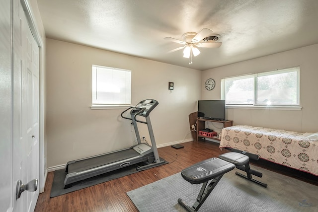 exercise room featuring ceiling fan, baseboards, and wood finished floors