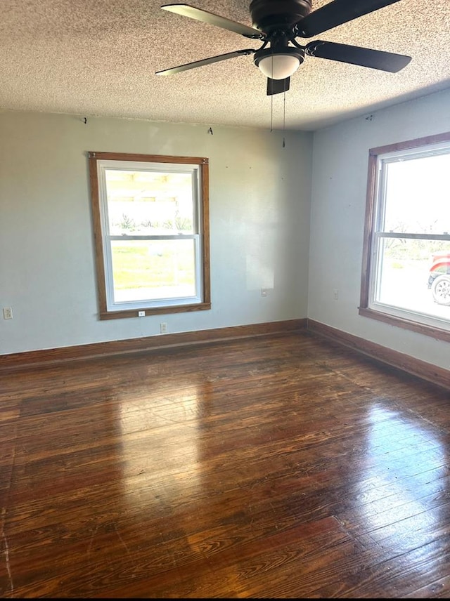 unfurnished room with ceiling fan, a textured ceiling, baseboards, and hardwood / wood-style floors