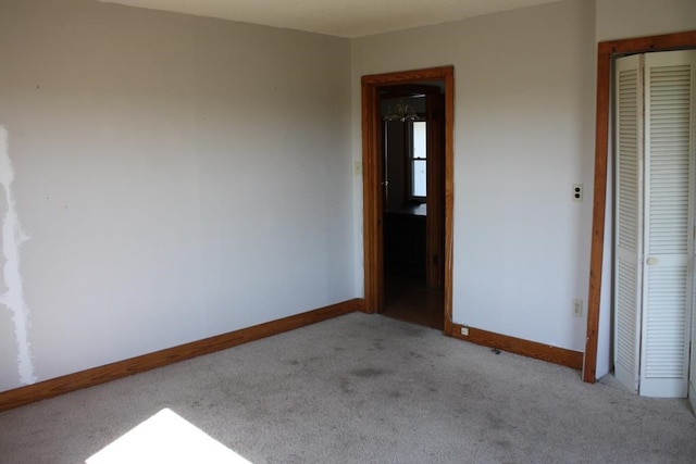 unfurnished room with carpet and baseboards