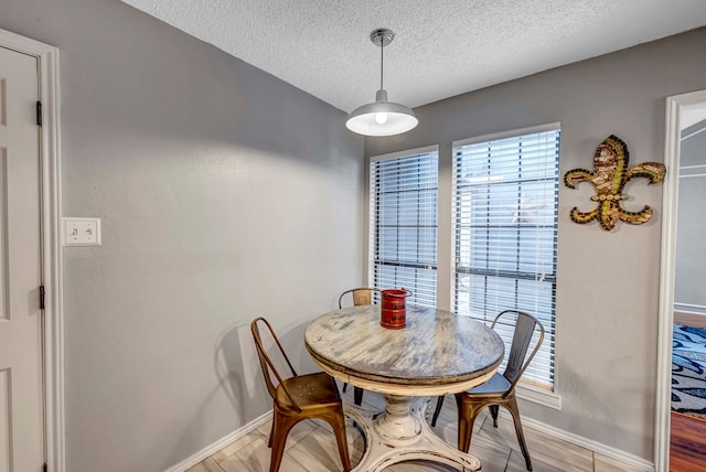 dining room featuring a textured ceiling and light hardwood / wood-style flooring