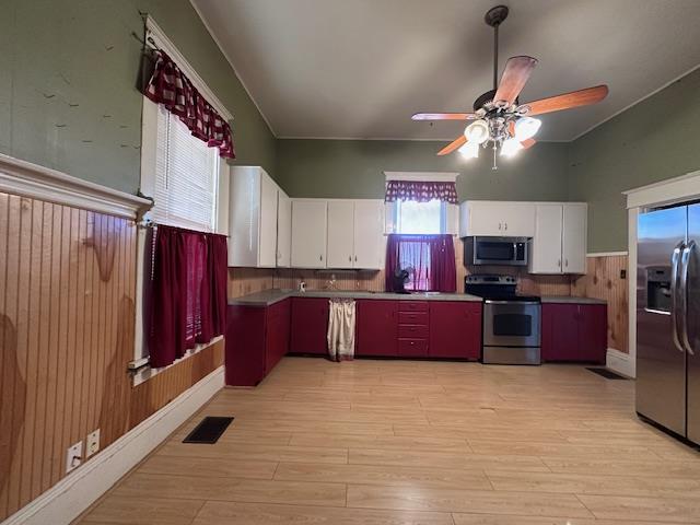 2311 30th St, Snyder, TX 79549 - kitchen with stainless steel appliances, ceiling fan, white cabinetry, and light wood finished floors