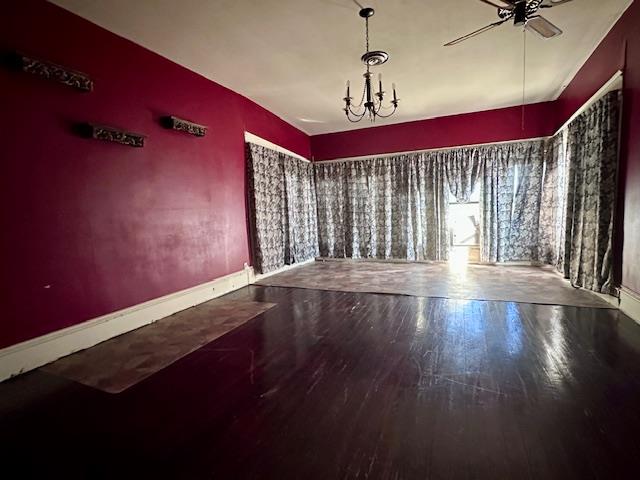 2311 30th St, Snyder, TX 79549 - spare room with wood finished floors, a ceiling fan, and a chandelier