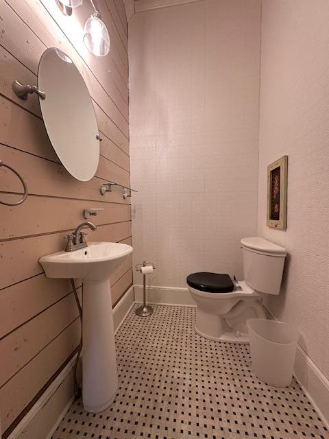 2311 30th St, Snyder, TX 79549 - bathroom featuring wood walls and toilet