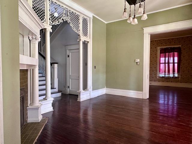 2311 30th St, Snyder, TX 79549 - unfurnished living room featuring wood finished floors, ornamental molding, and stairway