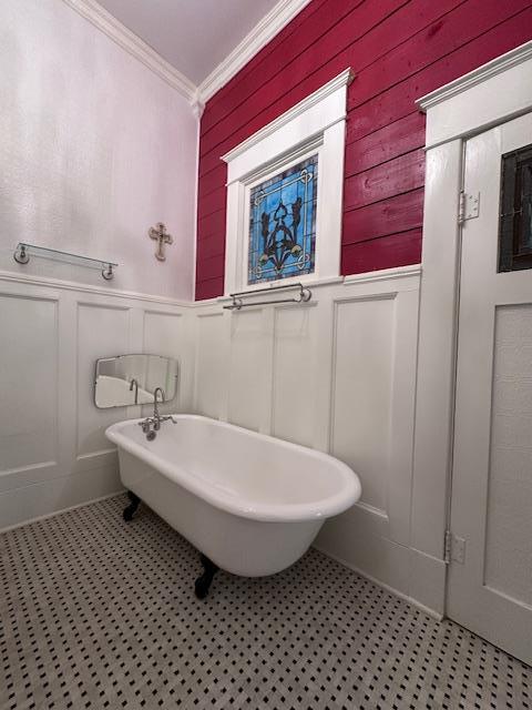 2311 30th St, Snyder, TX 79549 - bathroom featuring a decorative wall, ornamental molding, a freestanding tub, and a wainscoted wall