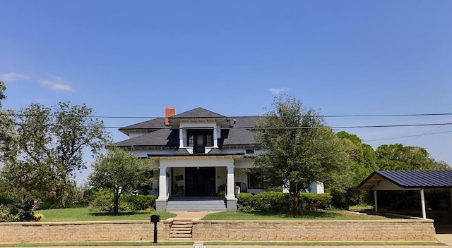 2311 30th St, Snyder, TX 79549 - view of front of property with covered porch, a front yard, and a chimney