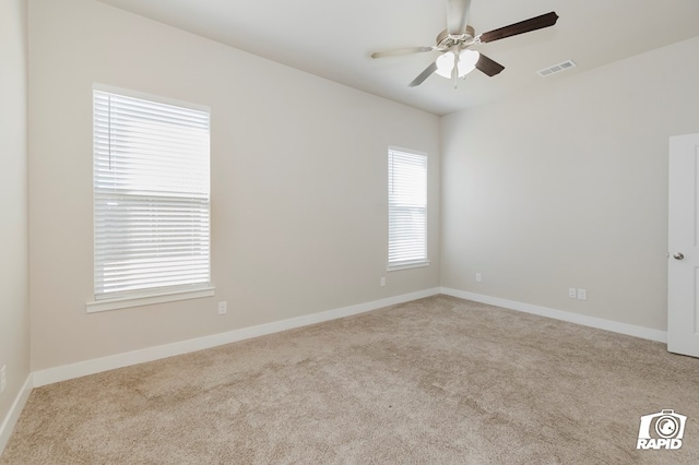 spare room with ceiling fan and light colored carpet