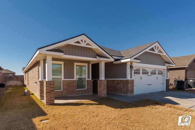 craftsman house with a garage, central air condition unit, and a front lawn