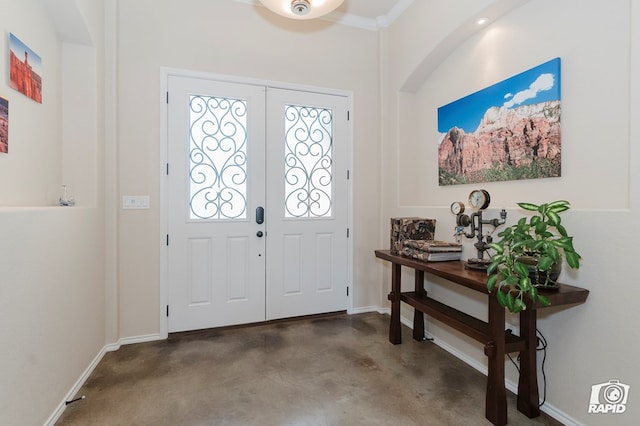 foyer entrance with concrete floors and baseboards
