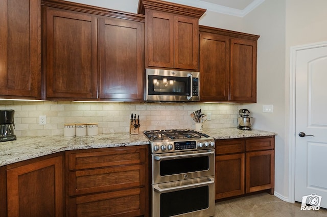 kitchen featuring stainless steel appliances, backsplash, ornamental molding, and light stone countertops