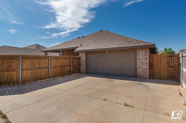 garage with fence and driveway
