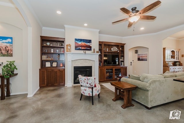 living room with concrete flooring, a ceiling fan, a brick fireplace, crown molding, and recessed lighting